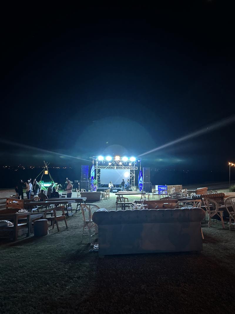 Escenario con pantalla LED y sector de living al aire libre